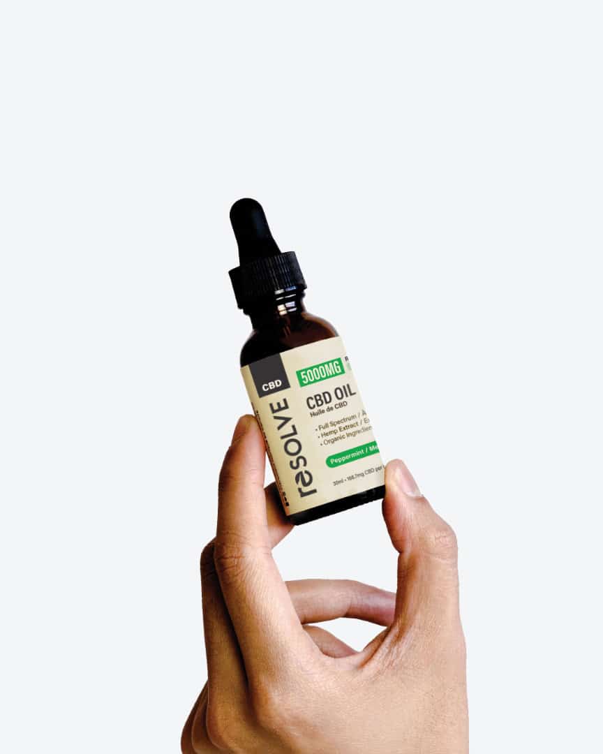 a Bottle of resolveCBD 5000mg Max CBD Oil held up by a hand