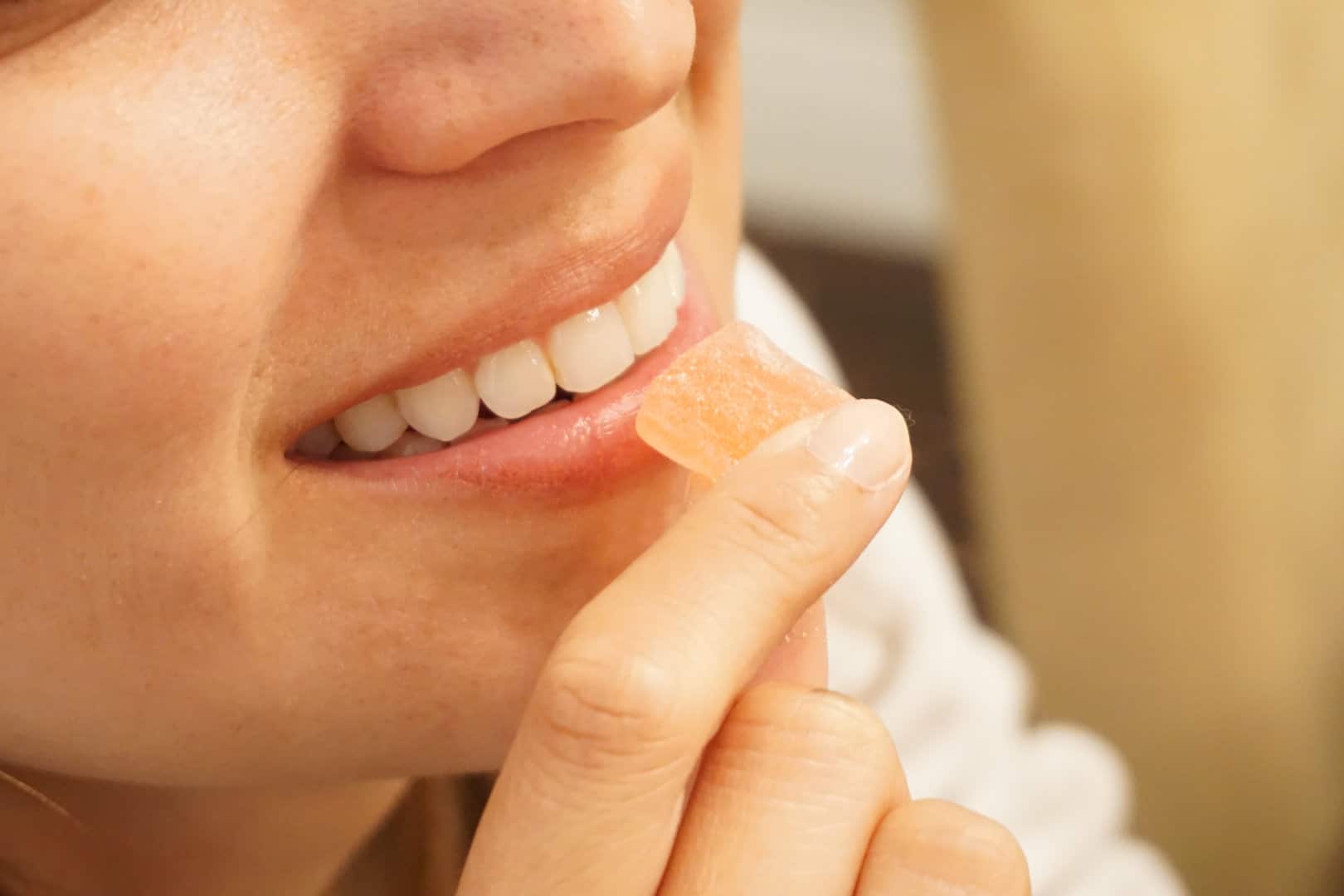 Woman about to put a CBD gummy edible in her mouth to eat