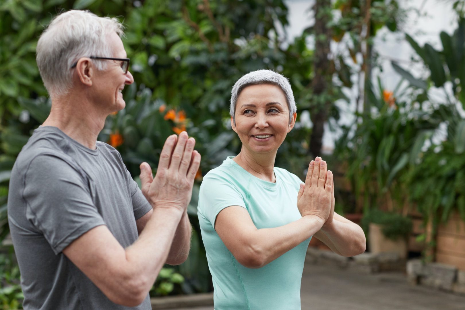 Older Couple doing yoga together looking at each other and smiling
