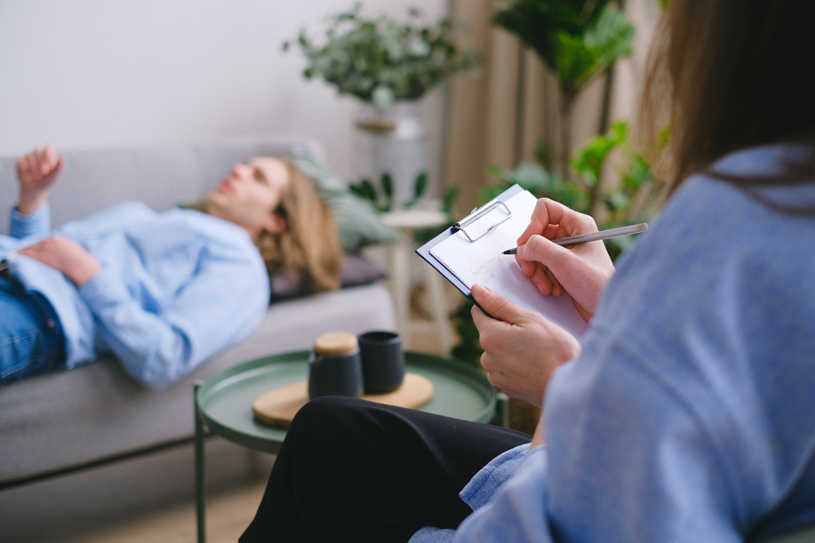 Woman laying on sofa talking to a therapist