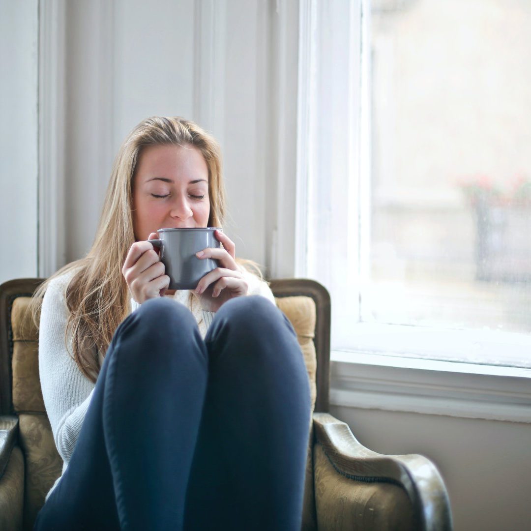 Woman sitting in her chair sipping on coffee